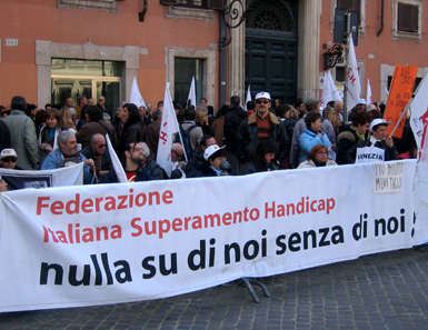 Persone che tengono manifesto Federazione Italiana Superamento Handicap "nulla su di noi senza di noi"