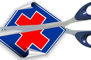 forbici che tagliano cartellino con croce della salute