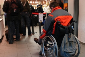 persona disabile in carrozzina dietro una fila