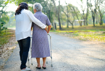 assistente aiuta donna anziana con deambulatore